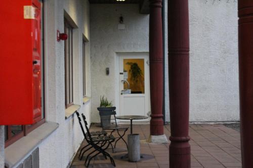 a patio with two chairs and a table in front of a door at Dalhall Hotell in Åmål