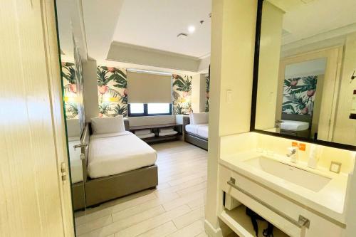 a hotel room with a bed and a mirror at Mella Hotel Manila near NAIA Airport in Manila