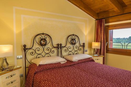 a bedroom with a bed with a red comforter and a window at Agriturismo dei Grippi in Sona