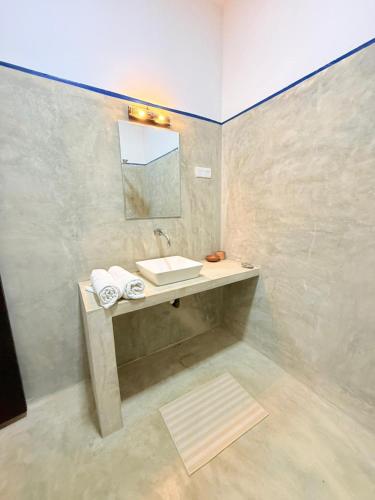 a bathroom with a sink and a mirror at Ma'Moon Beach Villa in Wadduwa