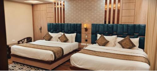 two beds in a hotel room with two bedsvisor at Hotel Mantavya in Kakarmatha