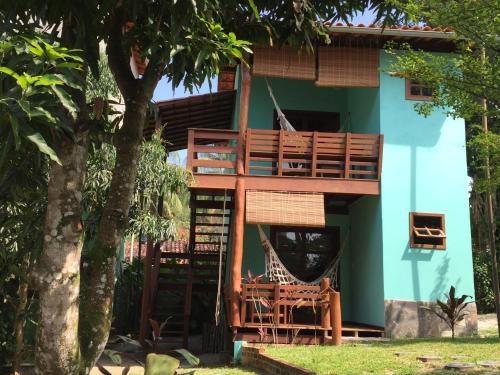 a tree house with a deck and chairs in front of it at Vila Sofia chalès in Morro de São Paulo