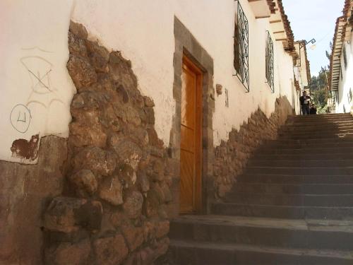 a building with stairs and a wooden door at Casa De Mama Cusco - The Treehouse in Cusco