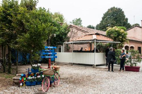 a group of people standing outside a house with a bike at Agriturismo Villa Mocenigo in Mirano
