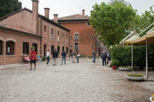 a group of people walking in a courtyard of a building at Agriturismo Villa Mocenigo in Mirano