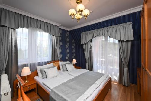 ボガーチにあるRajna VillaBridge&SPAのベッドルーム1室(青い壁と窓のある大型ベッド1台付)