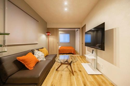 a living room with a couch and a tv at Lino Stay Kasai 'elua in Tokyo
