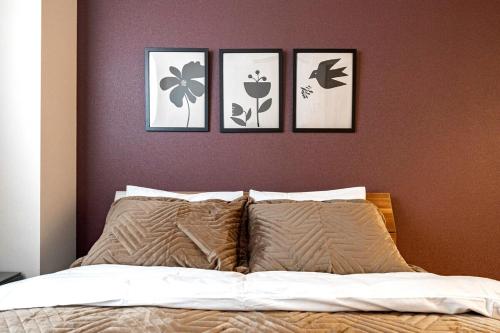 a bedroom with four pictures on the wall above a bed at Lino Stay Kasai 'elua in Tokyo