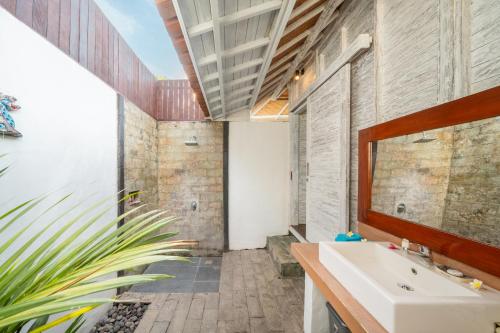 a bathroom with a sink and a mirror at Bukit Taman Cottages in Nusa Lembongan