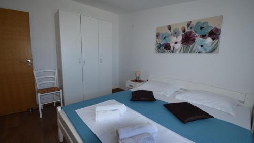 a bedroom with a bed with towels on it at Coastal Retreat Villa Milena by Villas Guide in Novalja