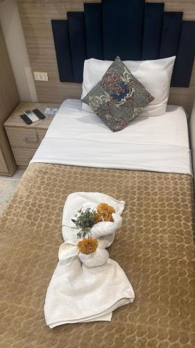 a hotel room with a bed with towels on it at Crown Home in Cairo