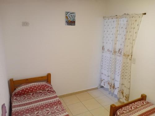 a room with two beds and a curtain at Happy House in Tanti