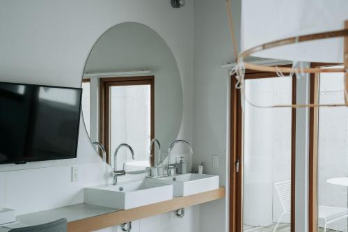 a bathroom with two sinks and a large mirror at KOTOBUKI Hotel in Kanoya