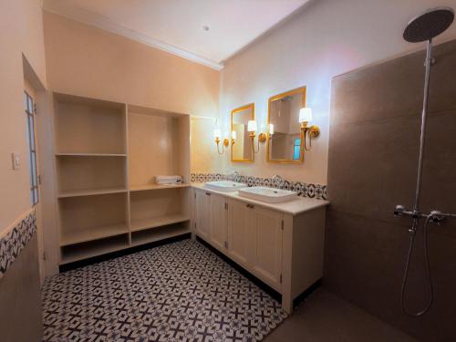 a bathroom with a sink and two mirrors and a shower at Pineridge Hotel at Mall Road in Darjeeling