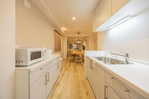 a kitchen with a sink and a microwave at Lino Stay Kasai 'ekol in Tokyo