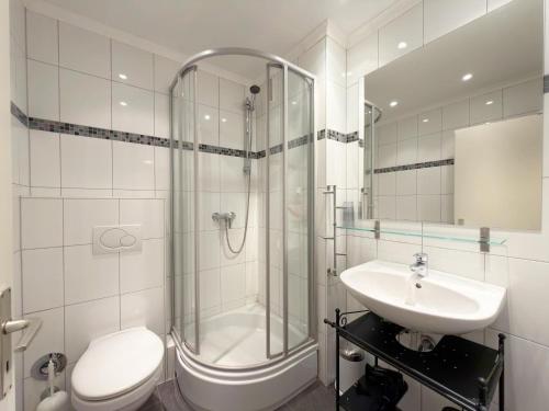 a bathroom with a shower and a toilet and a sink at Gemütliches App in Westerland mit Hund in Süderende