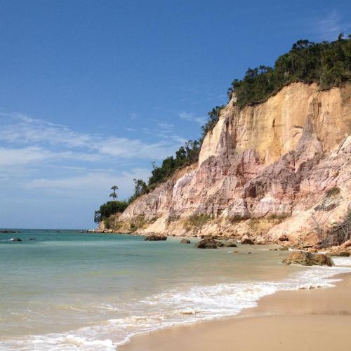 a view of a beach with a rocky cliff at Vila Sofia chalès in Morro de São Paulo