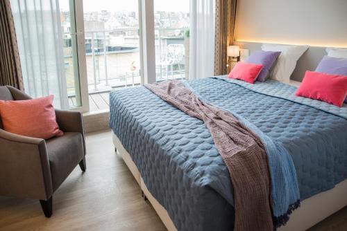 a bedroom with a large bed and a chair at ABC Hotel in Blankenberge