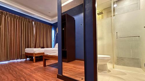 a bathroom with a toilet and a shower at Hotel Palacio Puerto Princesa in Puerto Princesa City