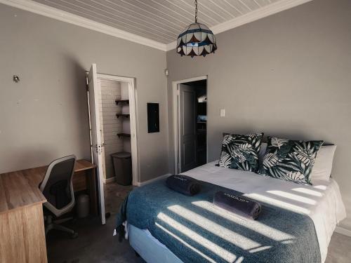 a bedroom with a bed and a desk and a chair at Dolphin View Accomodation in Strandfontein