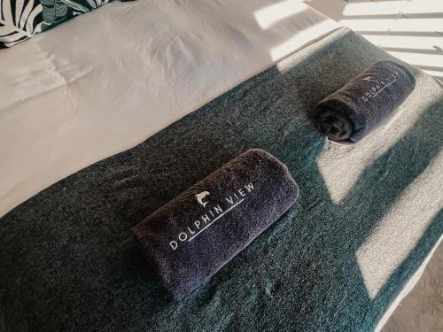 a dog laying on a bed with a remote control at Dolphin View Accomodation in Strandfontein
