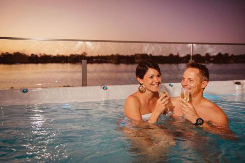 a man and a woman in a swimming pool at Ana Mandara Luxury Retreat in Port Macquarie