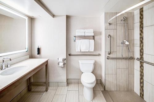 a bathroom with a toilet and a sink and a shower at DoubleTree by Hilton Madison Downtown in Madison