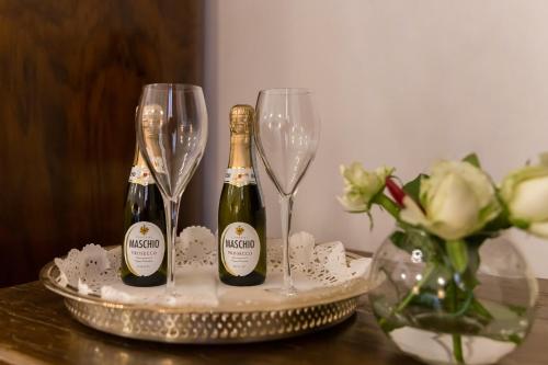 two bottles of champagne and two glasses on a table at Affreschi Su Roma Luxury B&B in Rome