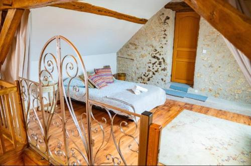 una camera da letto con un letto di metallo in una soffitta di Les Romarins a Vallières-les-Grandes