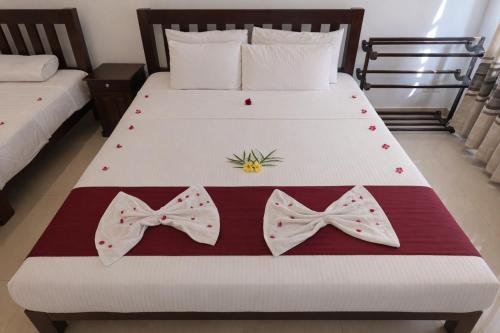 a bedroom with a bed with bows on it at Villa Sanitha in Ambalangoda