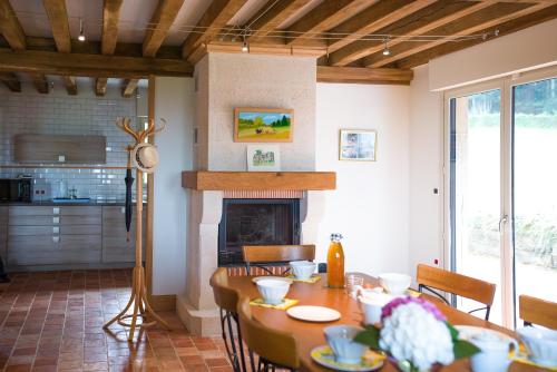 a dining room with a table and a fireplace at Holiday home Le clos du phare in Saint-Samson-de-la-Roque