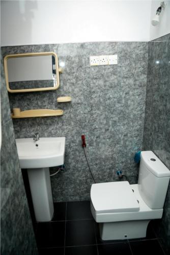 a bathroom with a toilet and a sink at Jaya Home Stay in Tangalle
