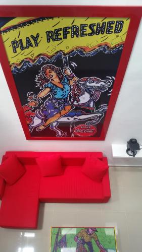 a shelf with a play reference sign above a red couch at Hostal Johnnier Macao Punta Cana in Punta Cana