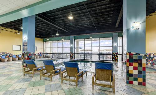 a pool in the middle of a room with chairs at Beach Quarters Resort in Virginia Beach