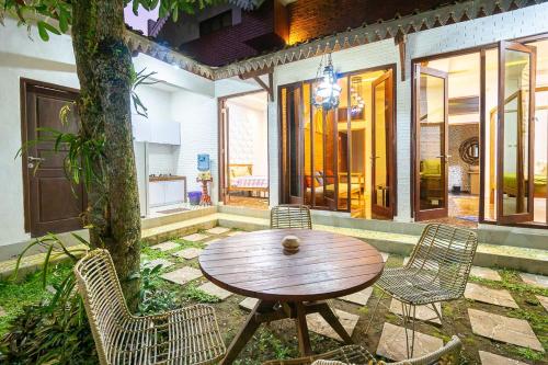 a wooden table and chairs on a patio at Villa Omah Rindu in Yogyakarta