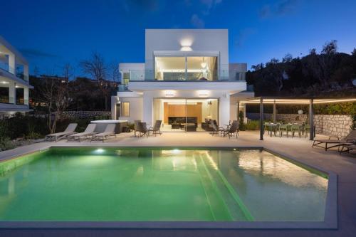 a house with a swimming pool in front of a house at Vista by Del Sol Villa in Rhodes Town