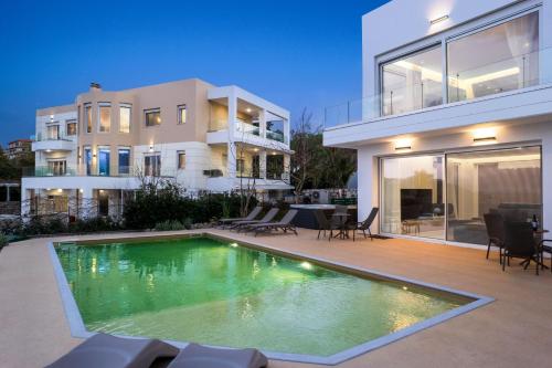 a swimming pool in front of a house at Vista by Del Sol Villa in Rhodes Town