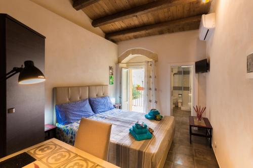 Schlafzimmer mit einem Bett, einem Tisch und Stühlen in der Unterkunft Antico Mercato in Ragusa