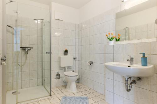 a bathroom with a toilet and a sink and a shower at Ferienwohnung Sonnendeck Moba-Travel in Priwall