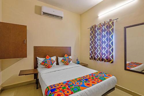 a bedroom with a large bed with colorful pillows at Via KR in Chennai