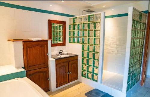 un bagno con vasca, WC e lavandino di Les Romarins a Vallières-les-Grandes