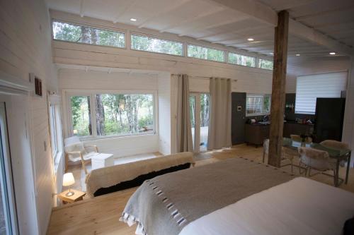 a bedroom with a large bed and a large window at Mareas Ralun Lodge in Ralún