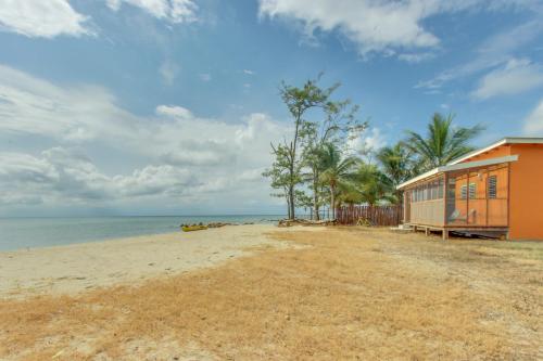 a house on the beach with the ocean in the background at Oceanus Cabanas in Dangriga