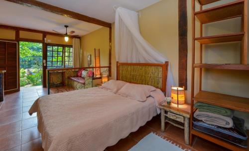 Un dormitorio con una cama grande en una habitación. en Pousada Villa Da Prainha, en Ilhabela