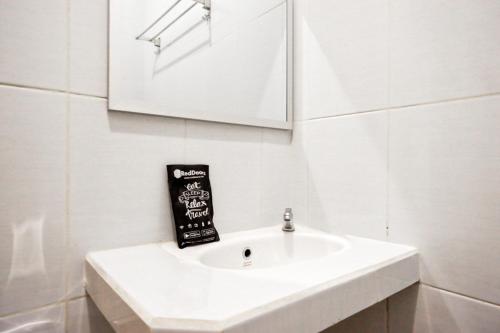 a bathroom with a white sink and a mirror at RedDoorz @ Jalan Wonosari KM.9 in Yogyakarta