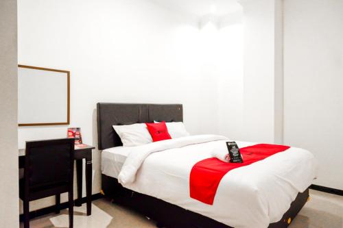 a bedroom with a large bed with a red bow on it at RedDoorz @ Jalan Wonosari KM.9 in Yogyakarta