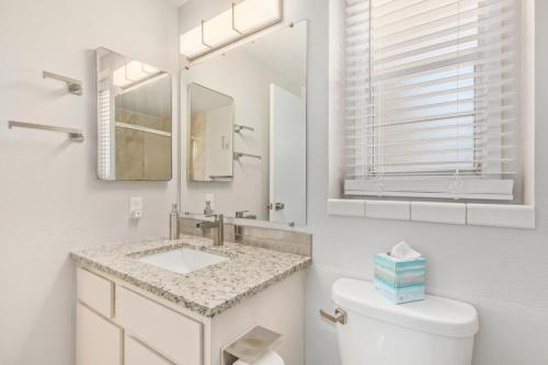 a white bathroom with a sink and a mirror at Naturally Modest & Quiet in Sun City West