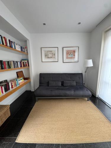 a black couch in a room with bookshelves at Luxury semi-detached house near Amsterdam in Loenen aan de Vecht