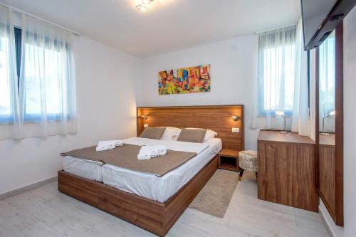 a bedroom with a large bed and a desk at Villa Marija in Sveti Filip i Jakov