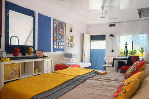 a bedroom with a bed with a yellow blanket on it at Sun Bloom in Mumbai
